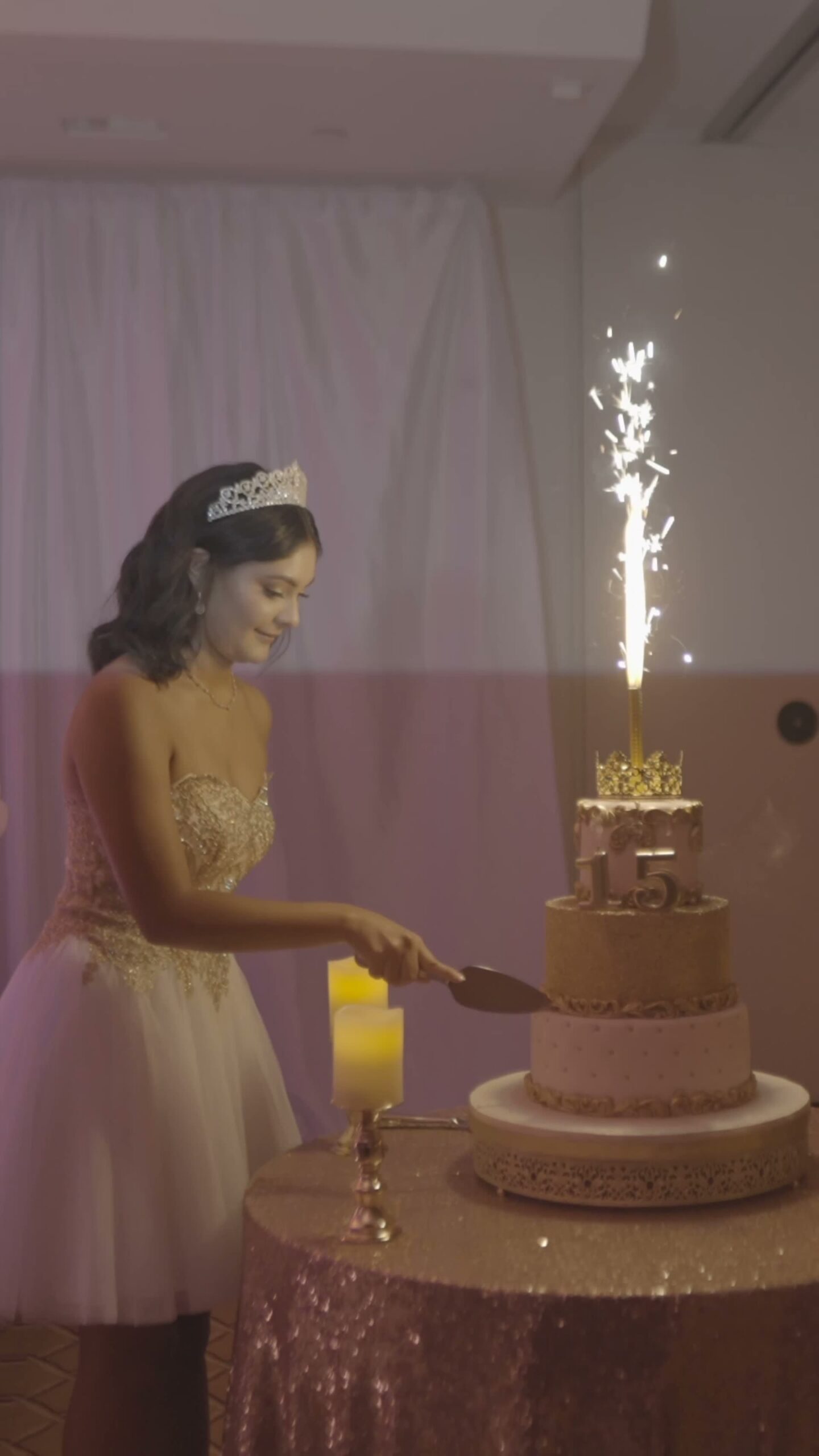 Quinceanera cutting her 15th birthday cake with a sparkler