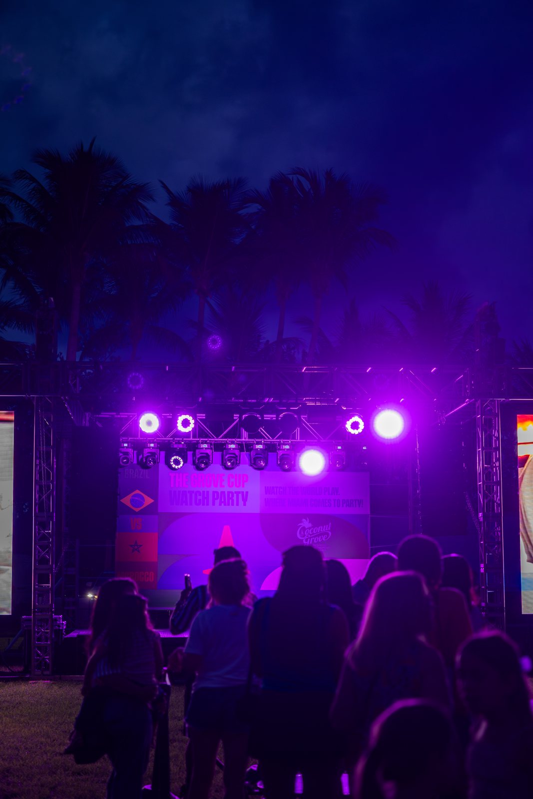 Magenta lighting wash across a night crowd