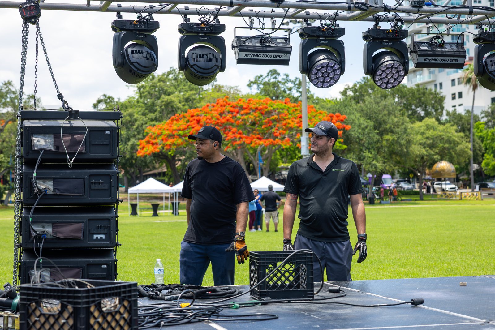 Moving head fixtures and line array speakers rigged on the stage deck