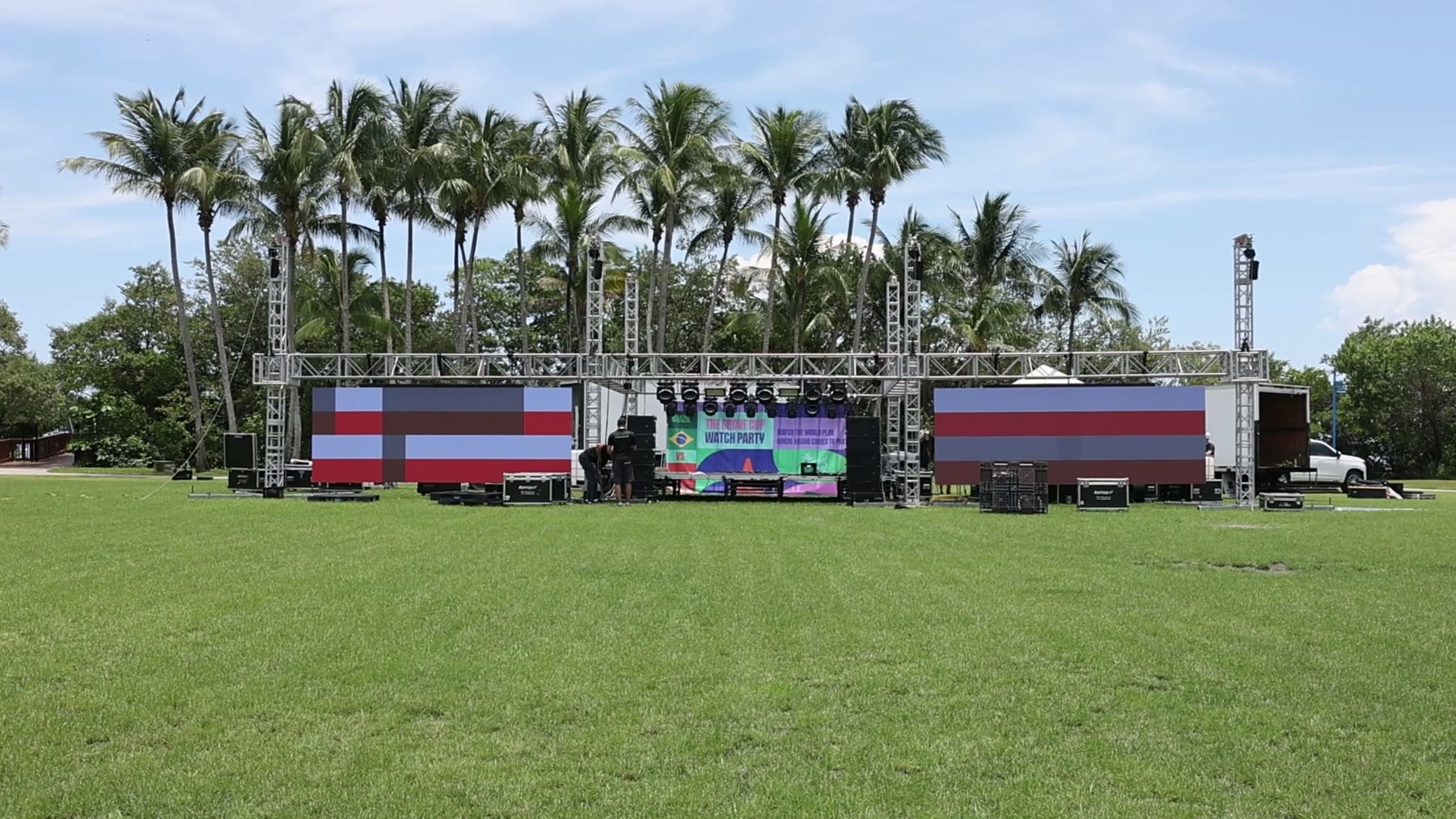 Completed stage with two large LED walls and truss towers on an empty field at Peacock Park